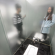 People pose for pictures as a public lavatory made mainly of glass opens to public at a park in Hunan province